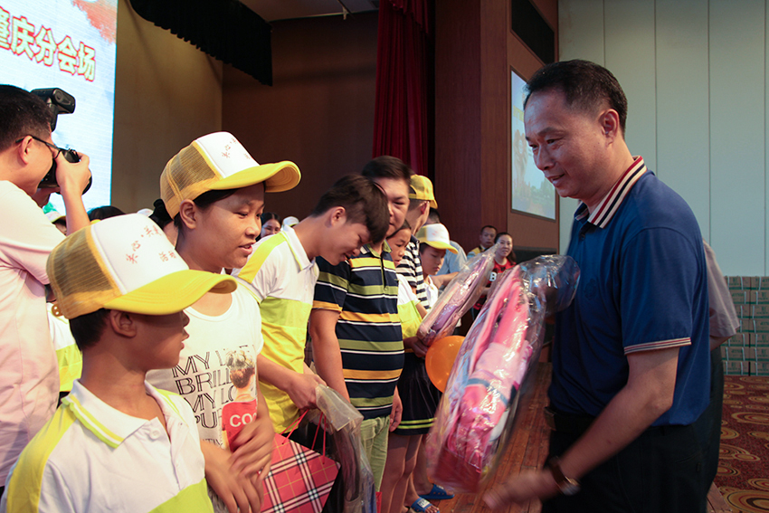9.梧州市總工會黨組書記、常務副主席梁耀忠為農(nóng)民工子女贈送書包、文具.jpg